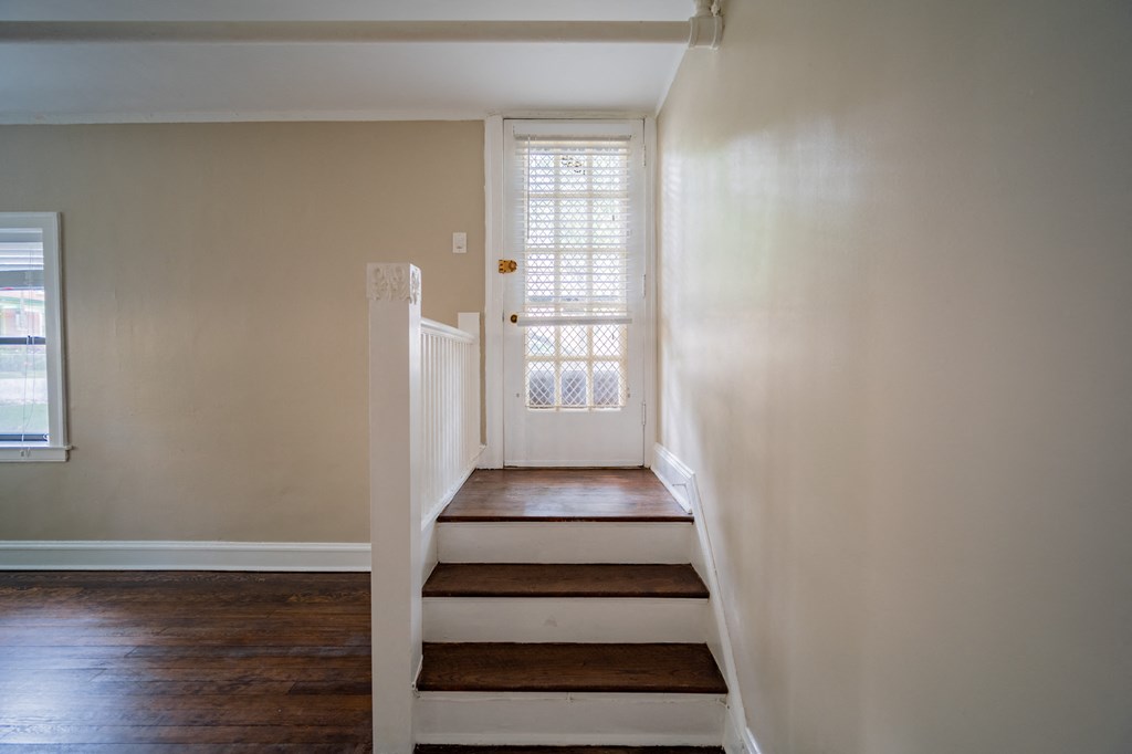 an empty staircase in a home with white walls and a window
