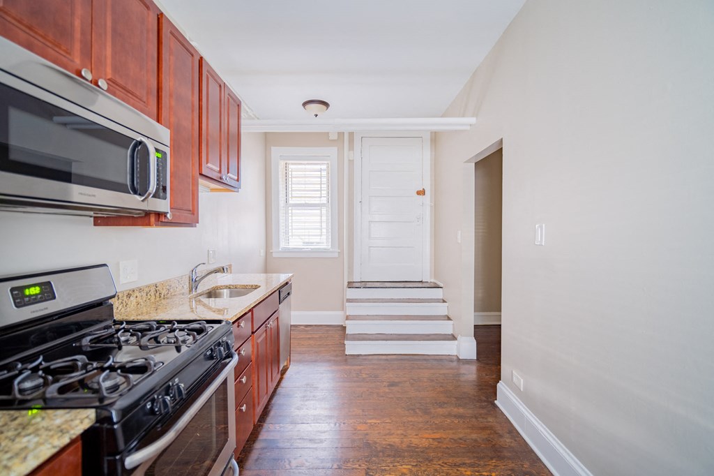 a kitchen with wood cabinets and a stove and a microwave