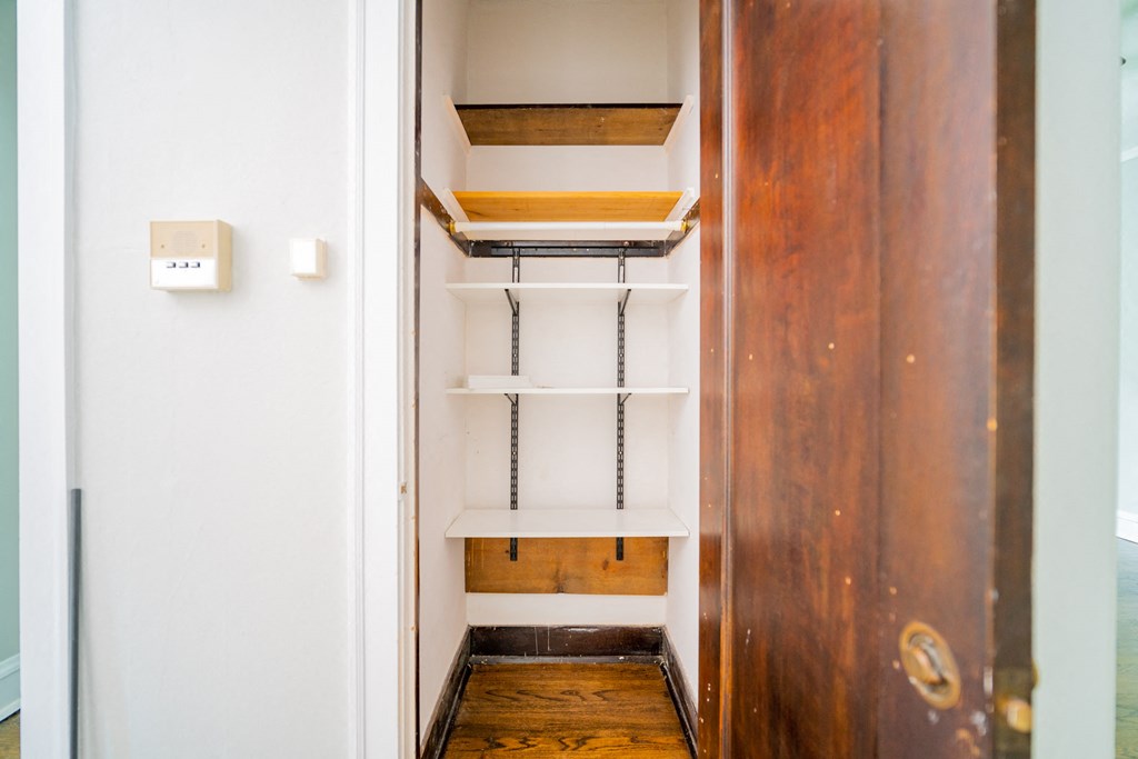 a walk in closet with shelves and a door