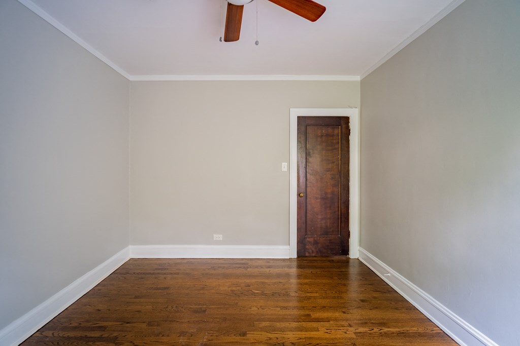 an empty room with wooden floors and a wooden door