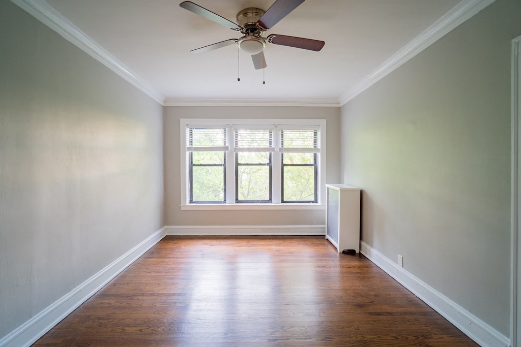 an empty room with a ceiling fan and a window