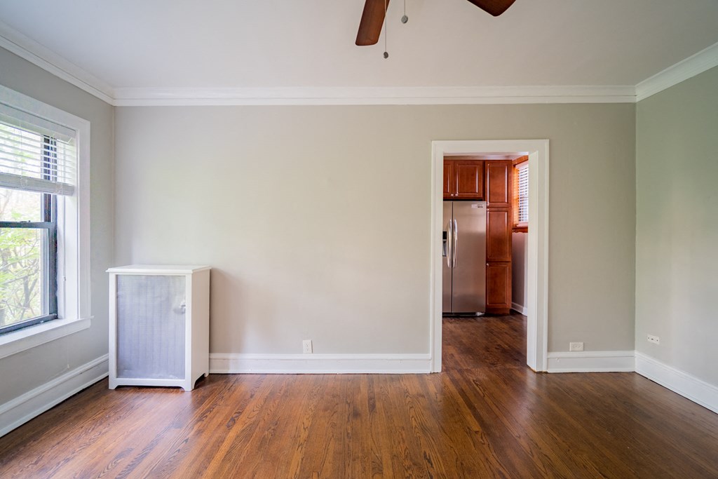 an empty living room with wood floors and a closet