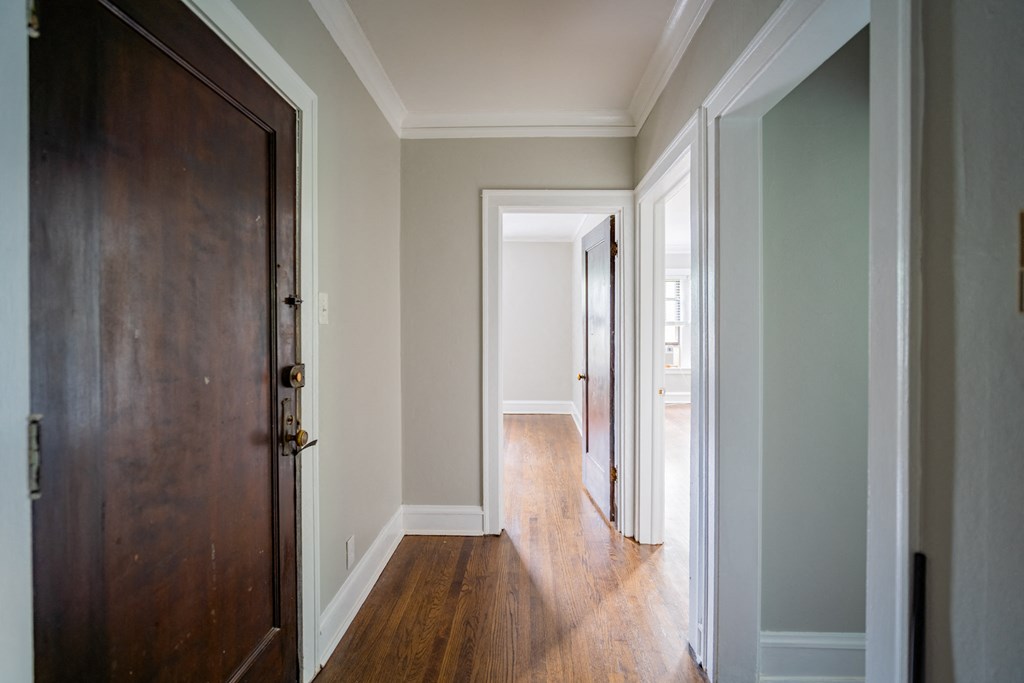 a hallway with wood floors and a wooden door