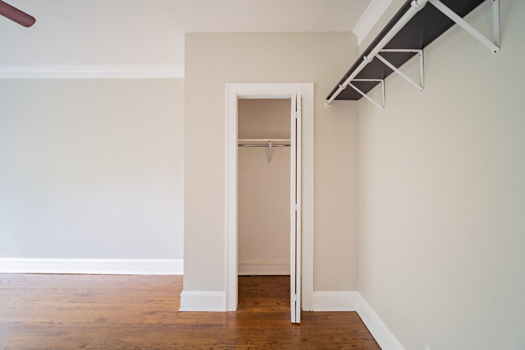 an empty room with a closet and a wooden floor