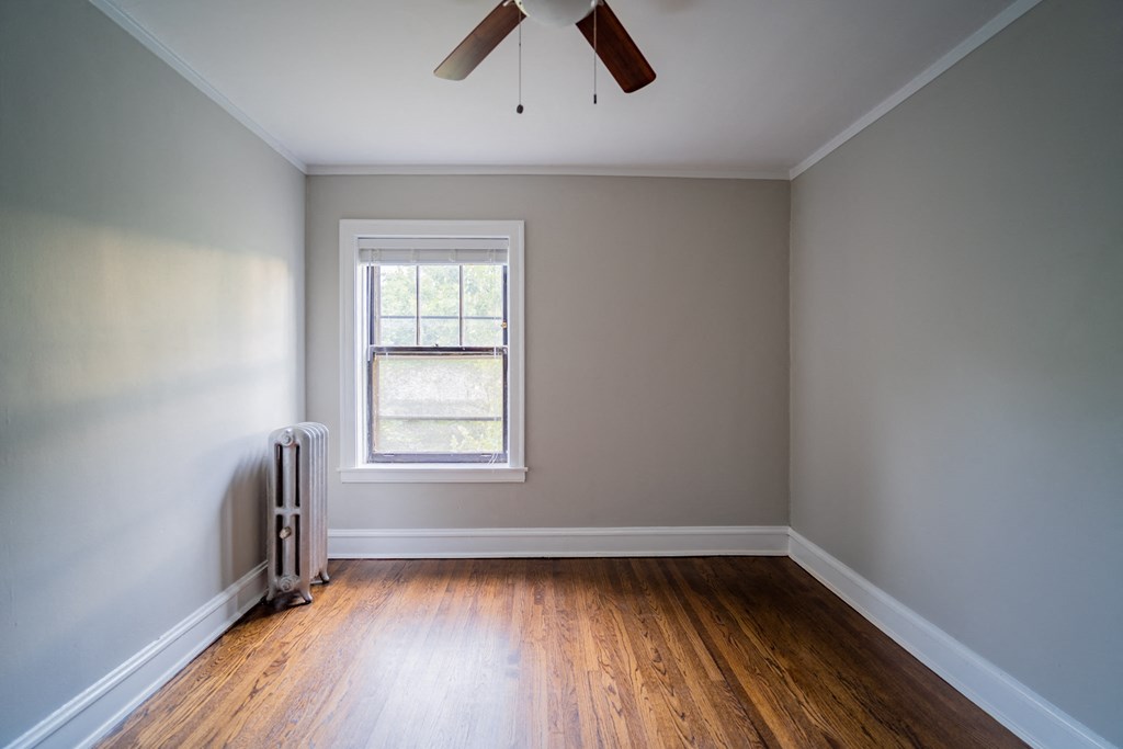 an empty room with a window and a ceiling fan
