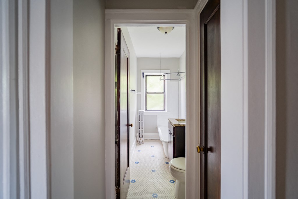 a bathroom with a toilet and a sink and a window