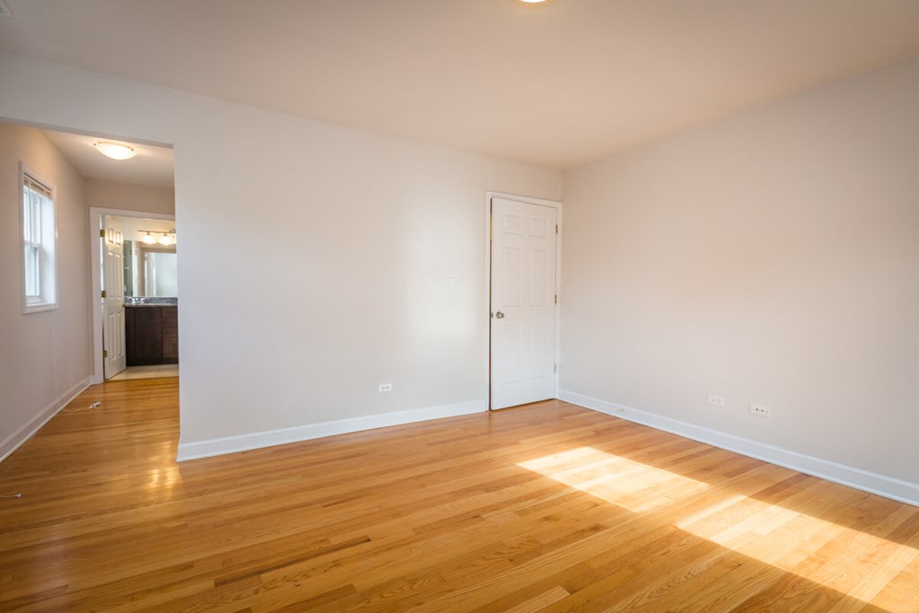 a living room with white walls and wood floors