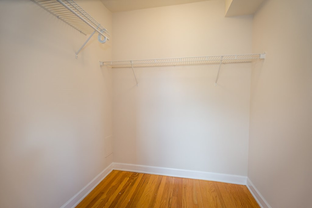 a empty room with a wood floor and a white wall with a white hanger