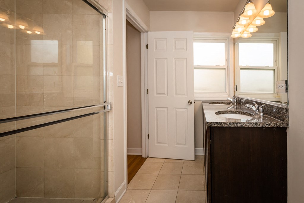 a bathroom with a sink and a shower and a door