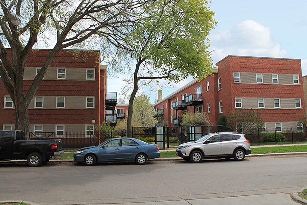 two cars parked in front of an apartment building