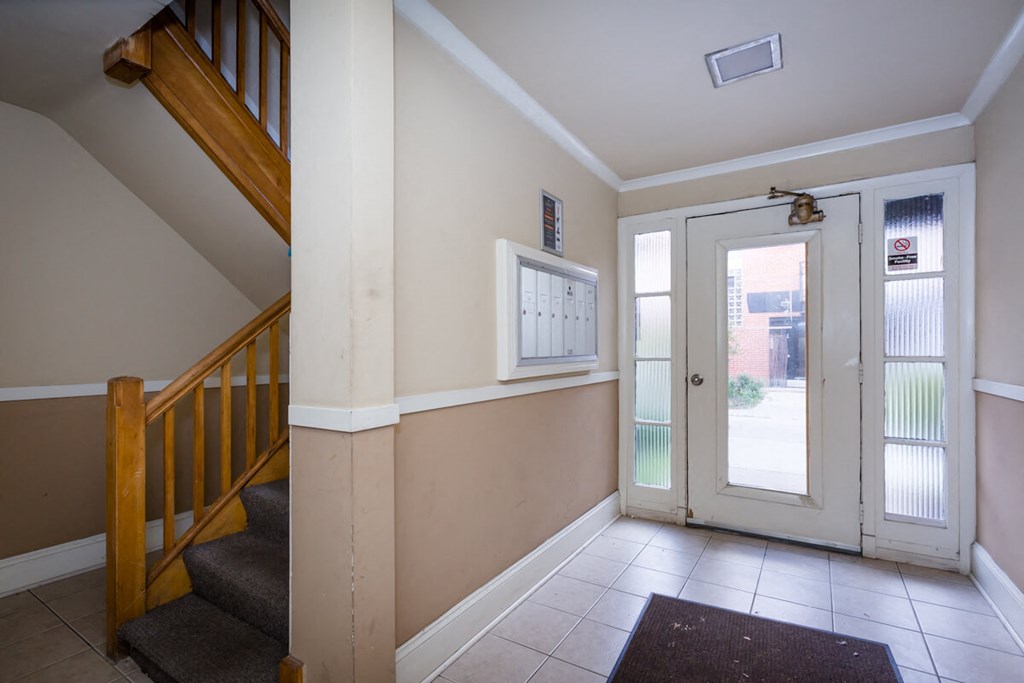 the entryway of a house with a staircase and a glass door