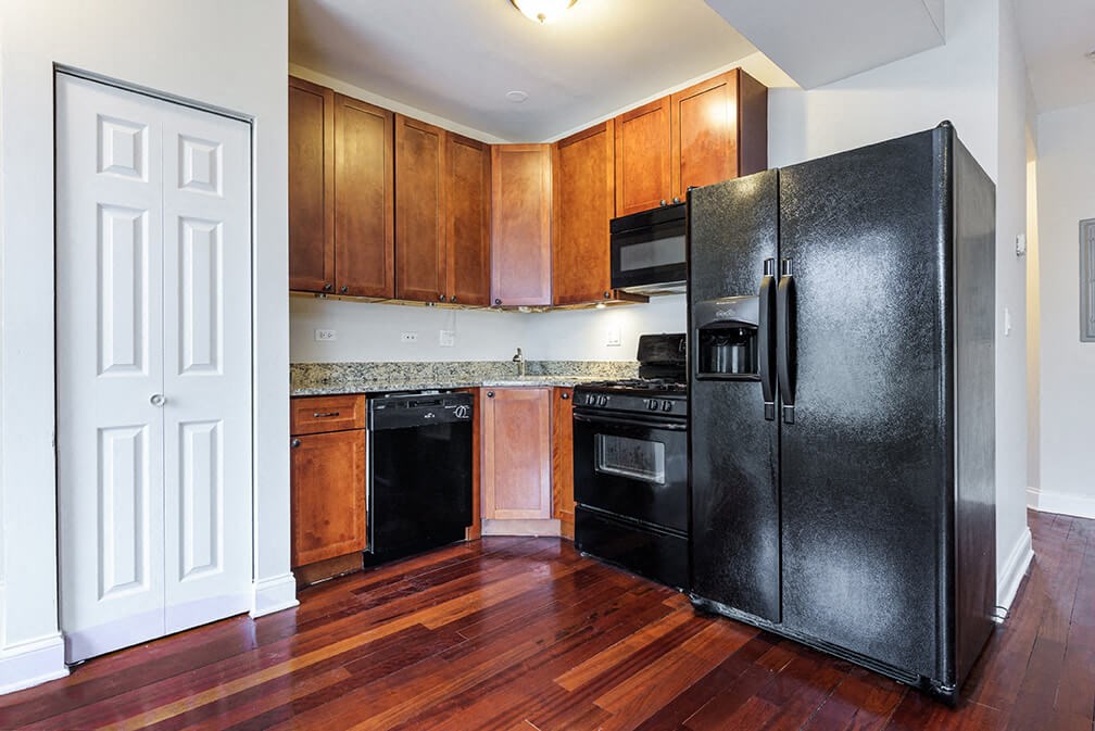 a kitchen with black appliances and wooden cabinets