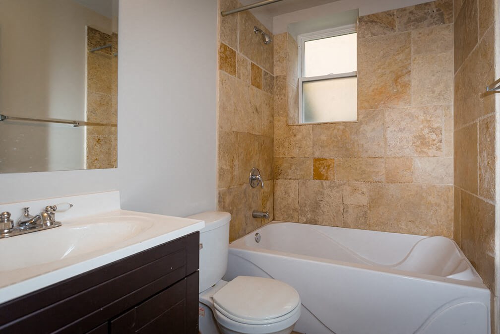 a bathroom with a toilet and a tub and a sink