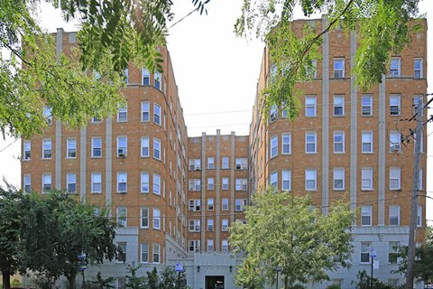 a row of brick buildings with trees in front of them
