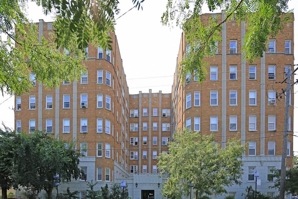 a row of brick buildings with trees in front of them