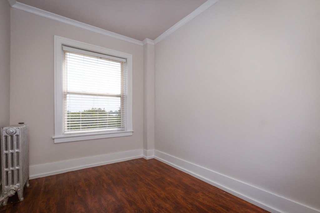 room with white walls and a window and wooden floors