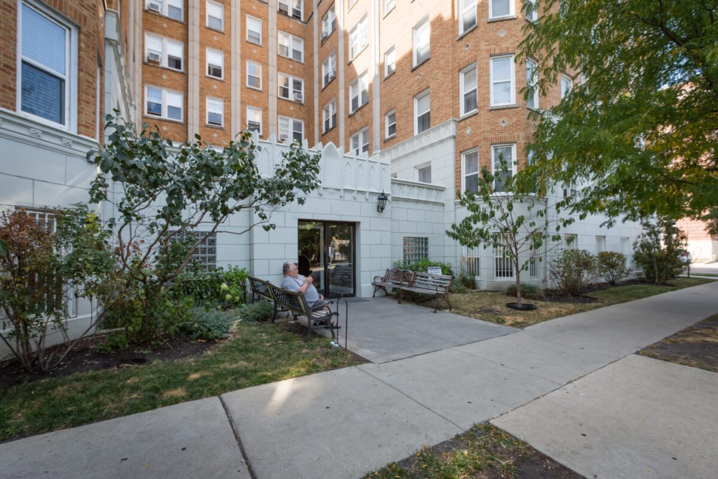 a person sitting on a bench in front of a building