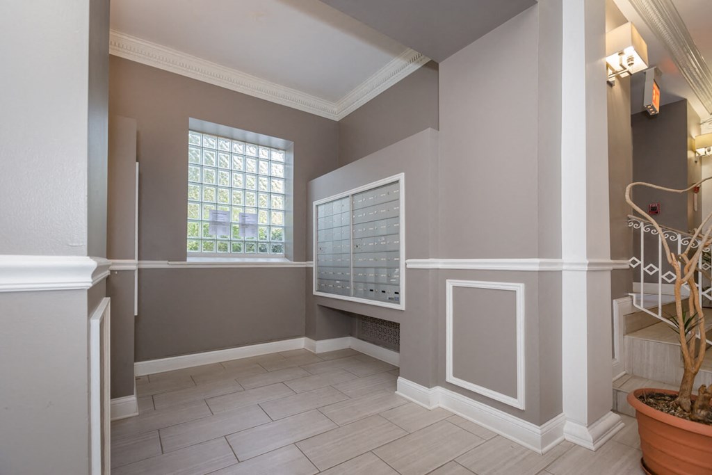 a foyer with a large window and a wall radiator and a plant