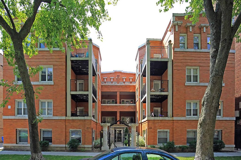 a car is parked in front of an apartment building