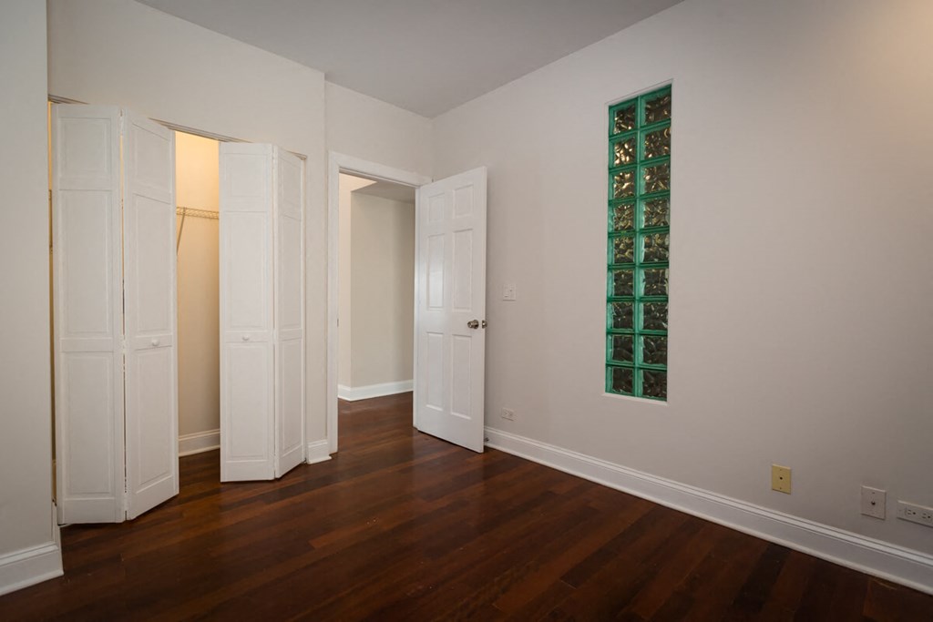 a living room with wood floors and a green glass window