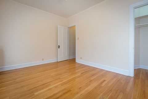 a empty living room with wood floors and white walls