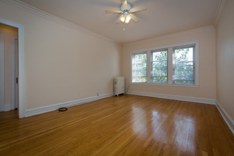 a living room with wood floors and a ceiling fan