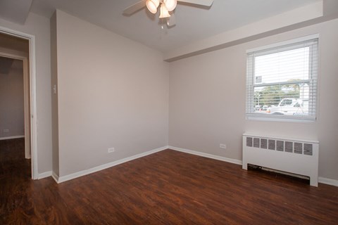 a living room with wood flooring and a ceiling fan