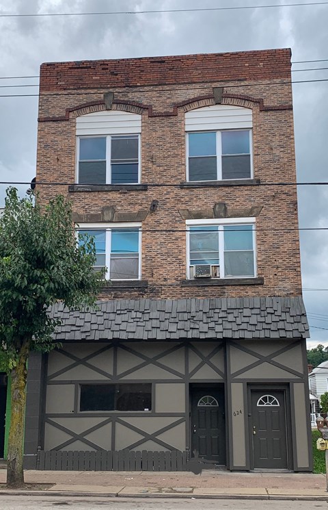 A two-story building with a brick facade and a black and white timbered section.
