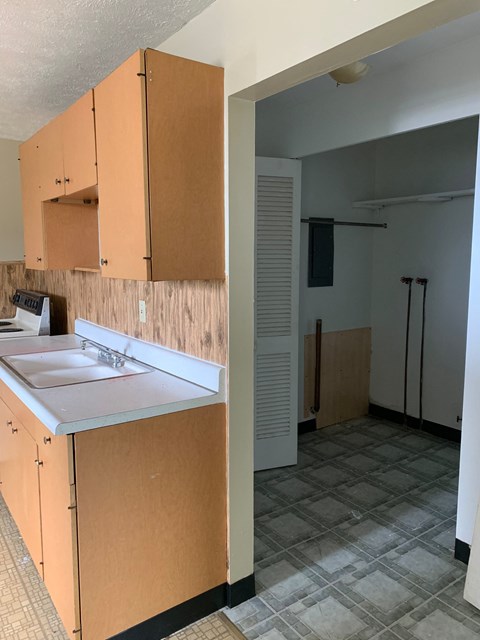 A kitchen with wooden cabinets and a white sink.
