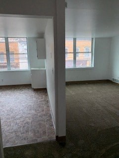 A room with a carpeted floor and a window.