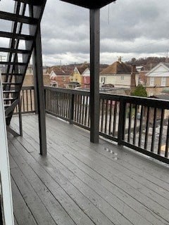 A wooden deck with a metal railing and a staircase.