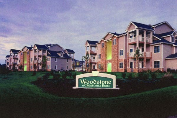 an apartment building with a sign in front of it