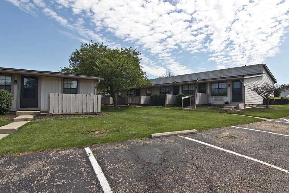an empty parking lot in front of a house
