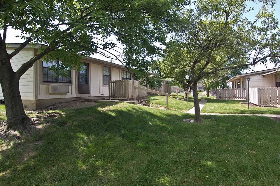a house with a yard and trees in front of it