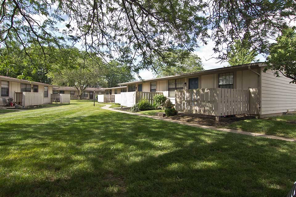 a group of houses with a yard and trees