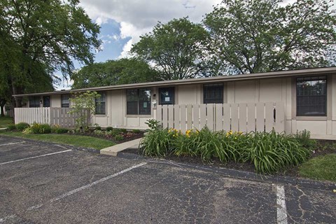 a white house with a white fence and plants