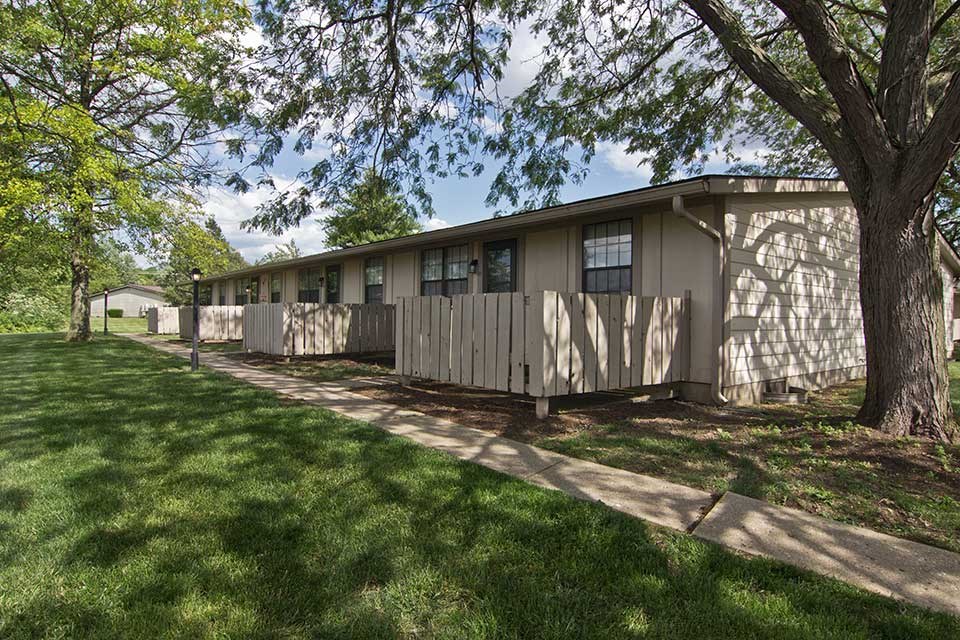 a mobile home is parked next to a tree