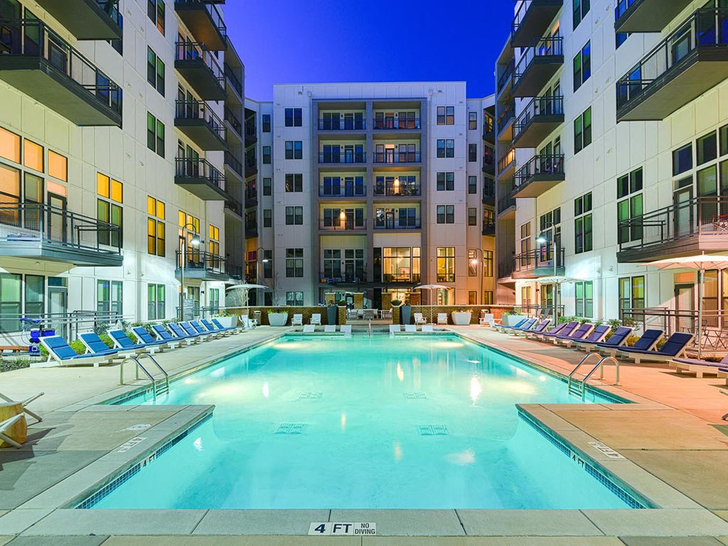 a swimming pool in the middle of an apartment building at night