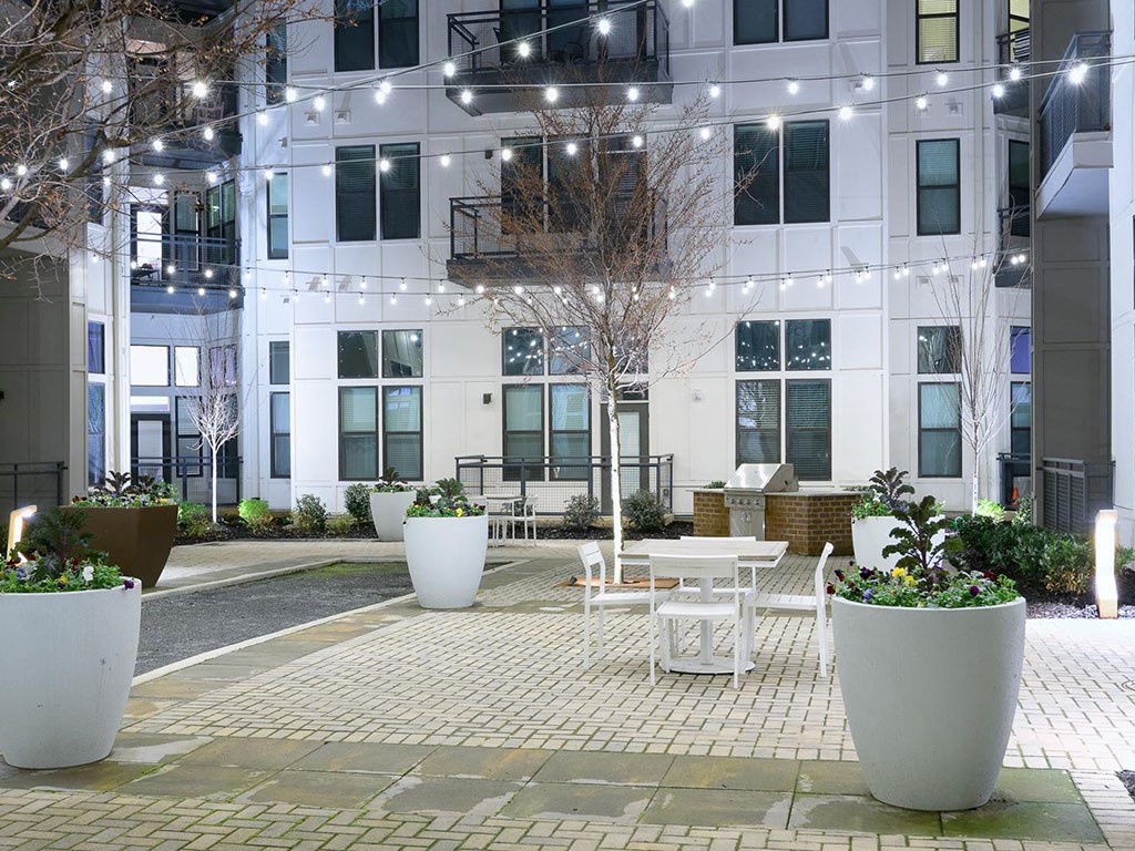 a courtyard with tables and chairs in front of a building