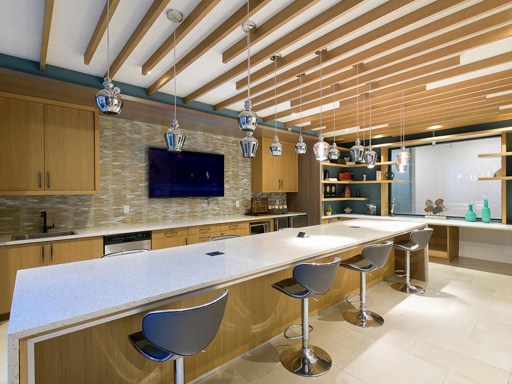 a large kitchen with a long counter and chairs