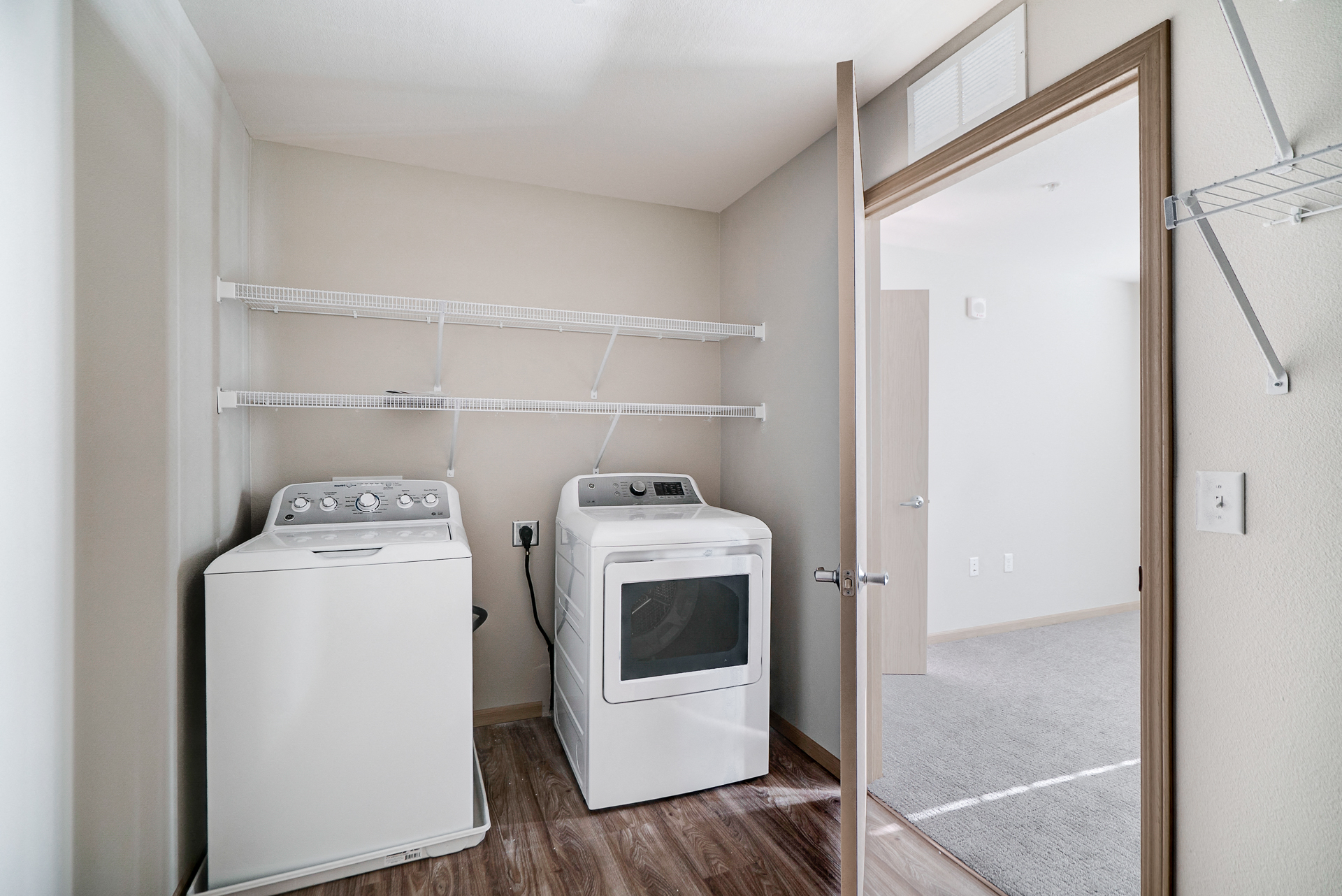 a laundry room with a washer and dryer and a mirror with a door