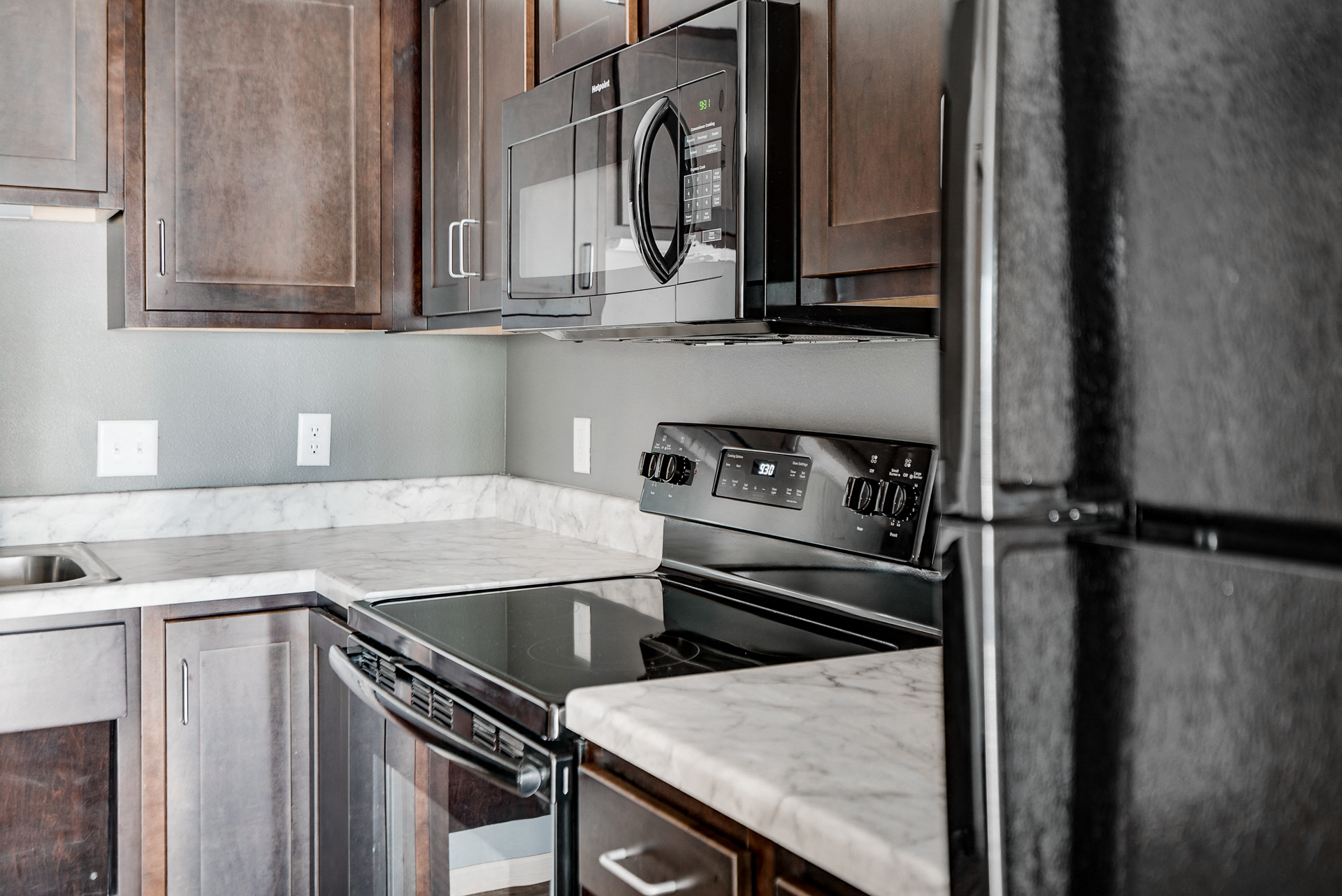an updated kitchen with stainless steel appliances and marble counter tops