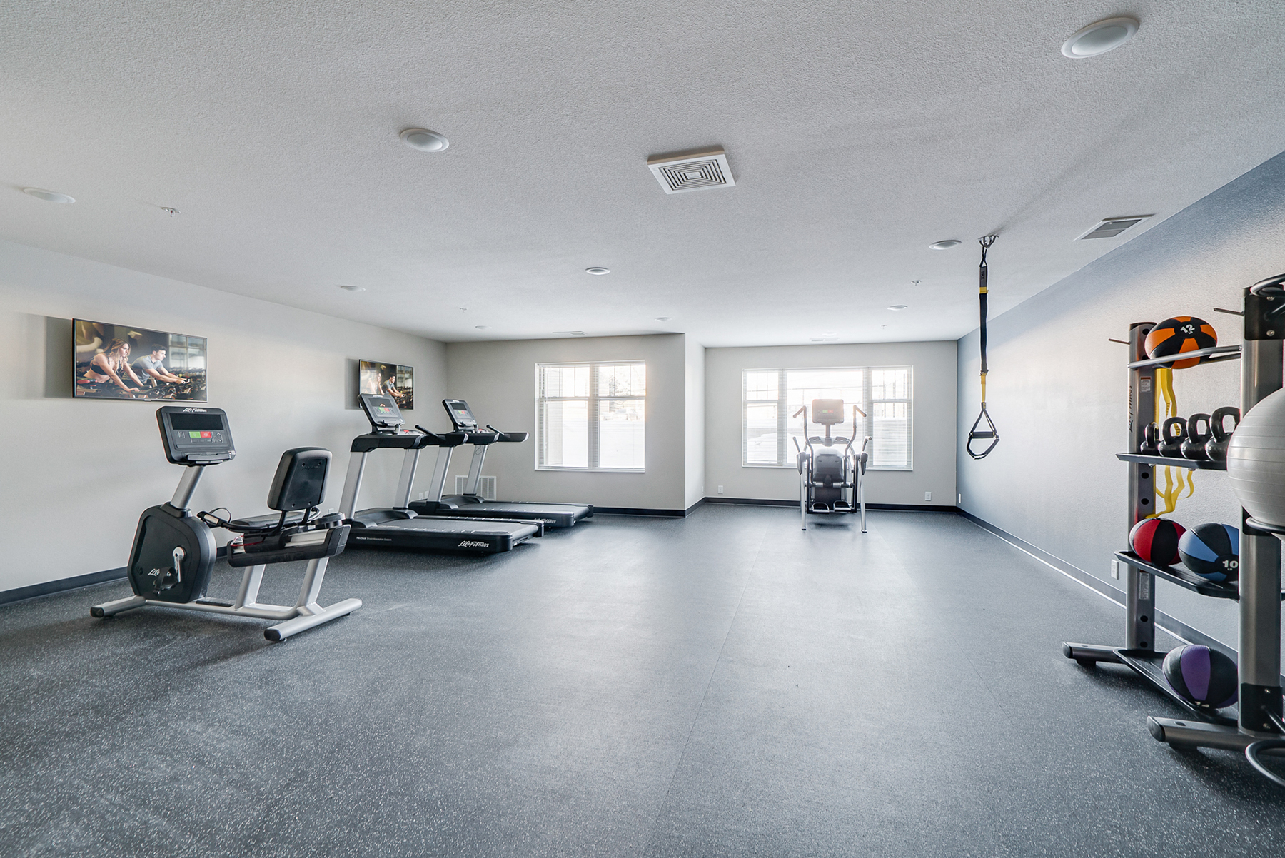 a fitness room with treadmills and other workout equipment