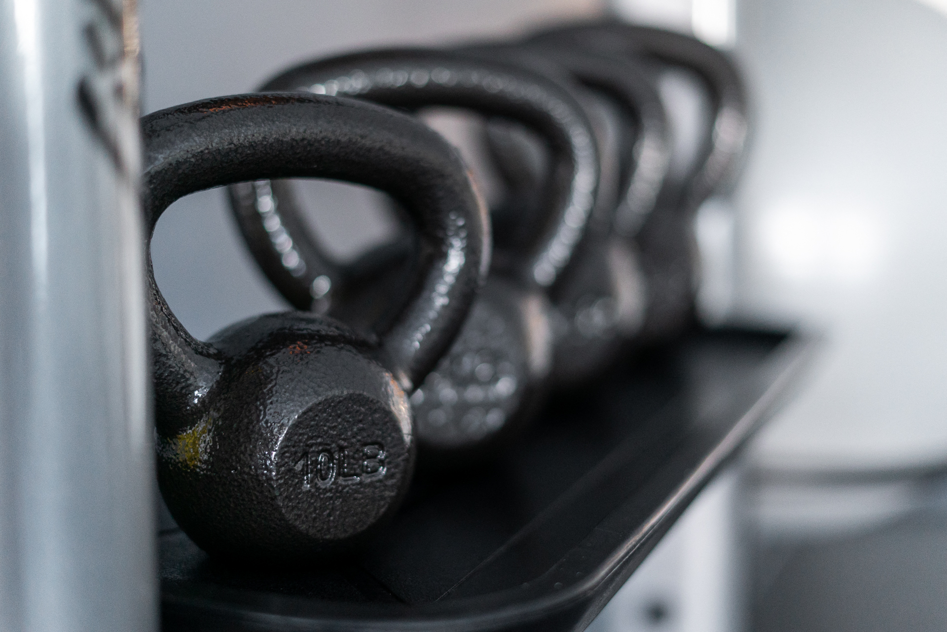 a row of dumbbells sitting on a shelf