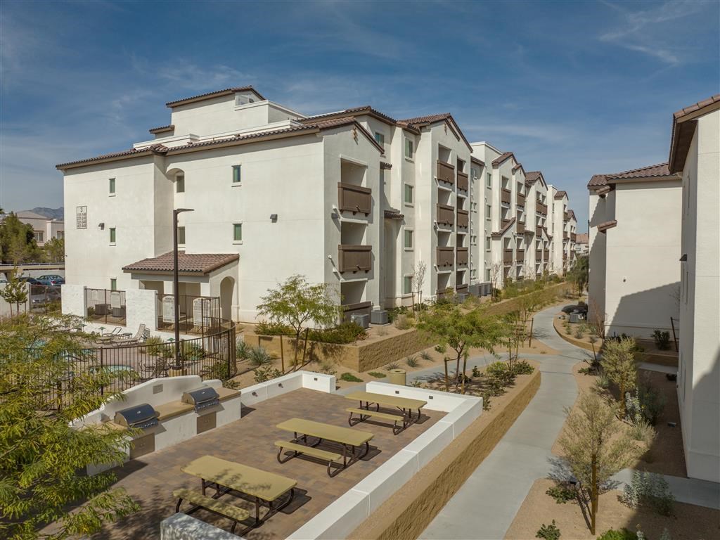 a group of apartments with tables and benches in a courtyard