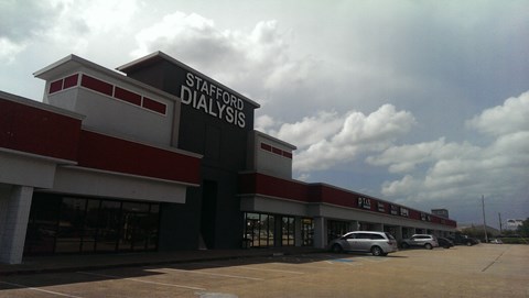 A Stafford Dialysis building with a car parked in front.