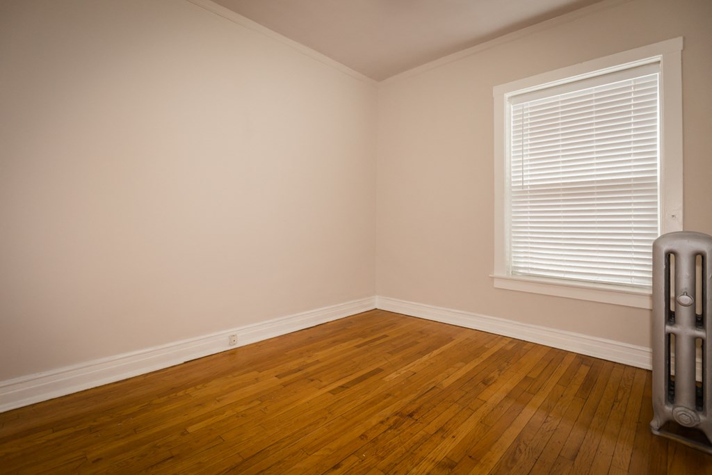 an empty room with wooden floors and a window