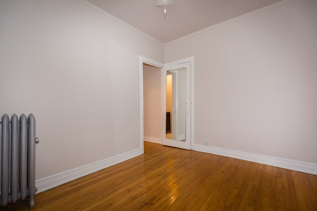 a empty room with wood floors and white walls