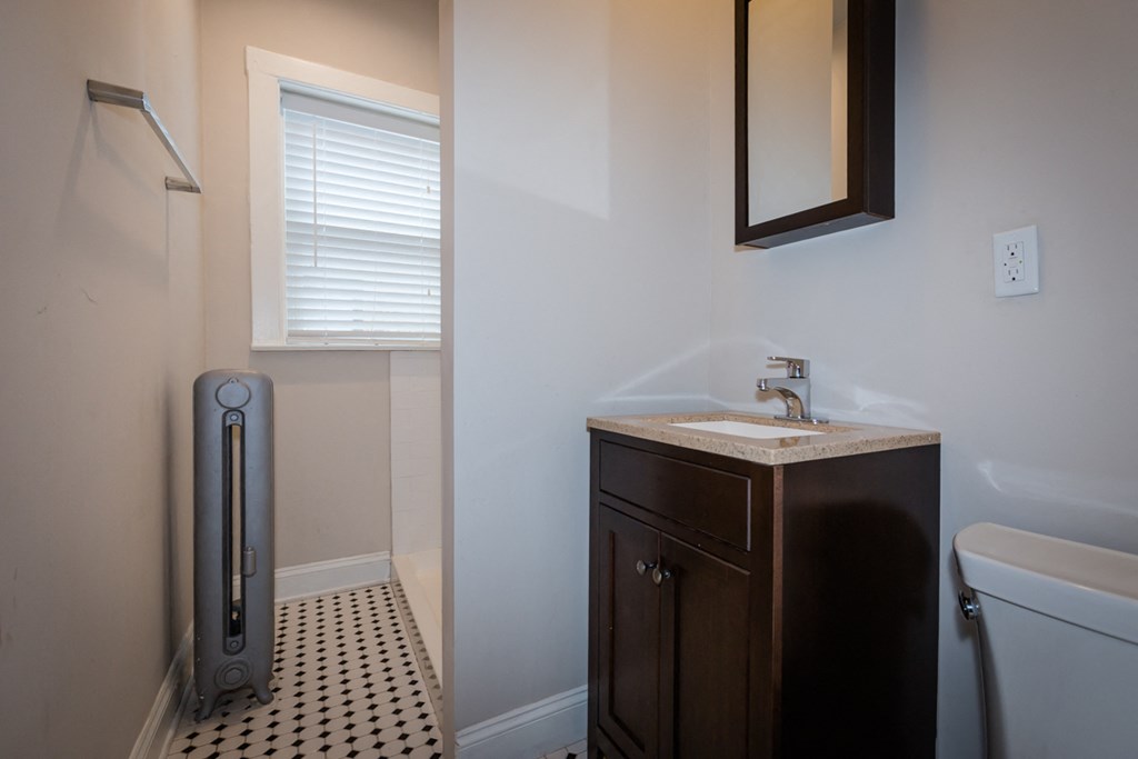 a bathroom with a toilet and a sink and a mirror