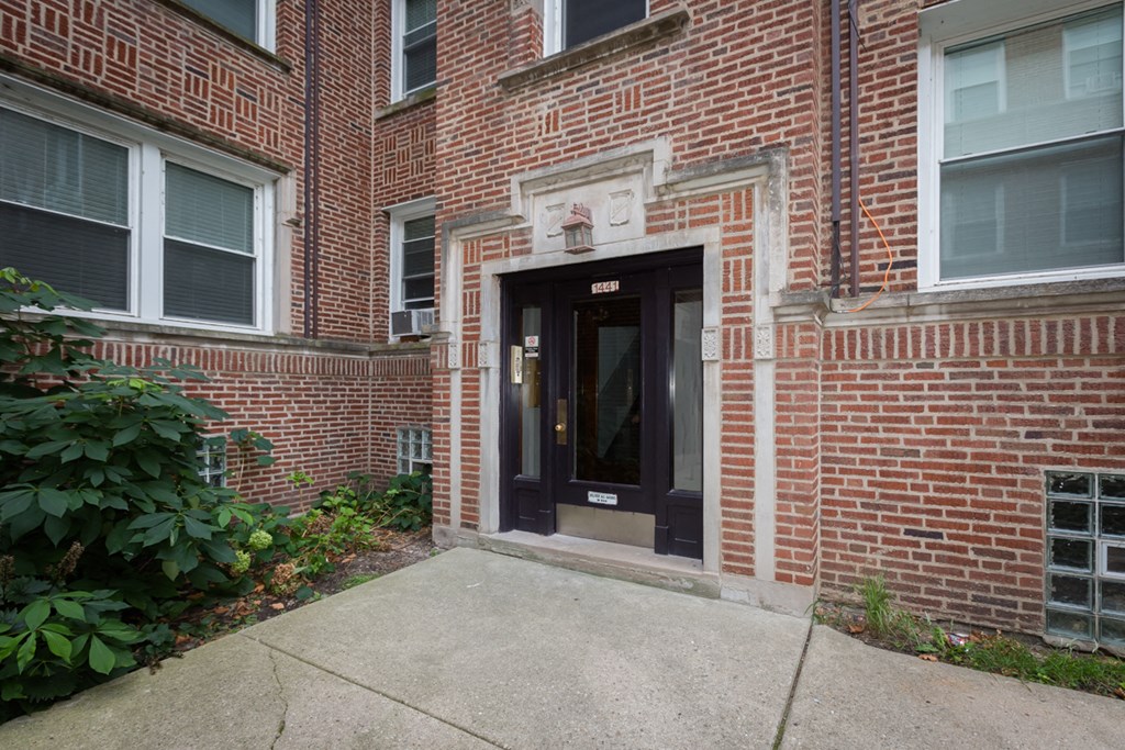 the front entrance of a brick building with a black door